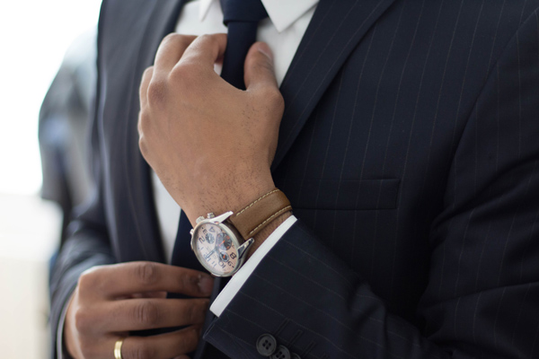 man straightening his tie